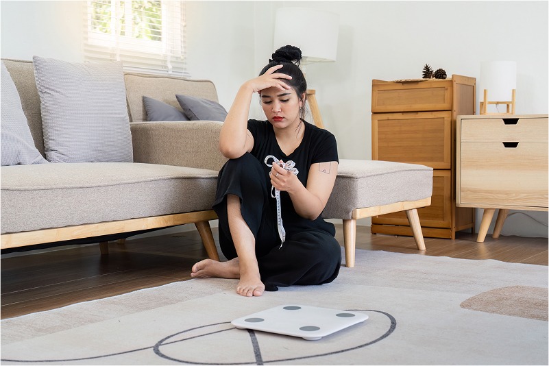 stressed-woman-sitting-on-floor-with-tape-measure-2025-01-10-05-56-15-utc